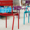 Low angle shot of various colored Luxembourg side chairs in a park.