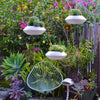 Three Orbit Hanging Planters staged in a chandelier effect with an Acapulco chair in the background.