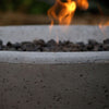 Close shot of flames coming from a concrete fire pit.