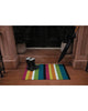 Bold multi stripe outdoor Chilewich mat by a front door.